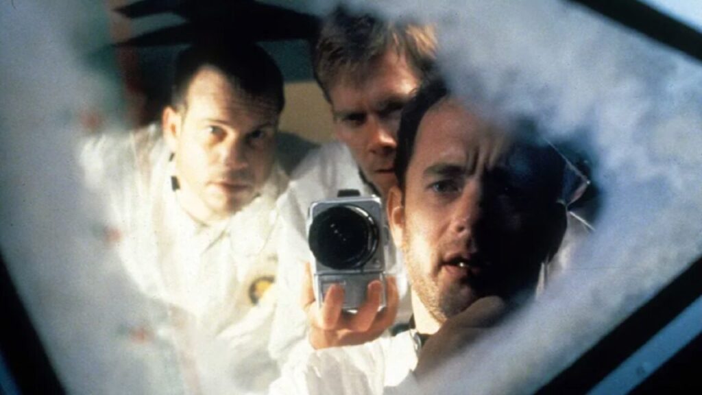 three astronauts staring out a small window in their spacecraft as ice builds up around the edges.