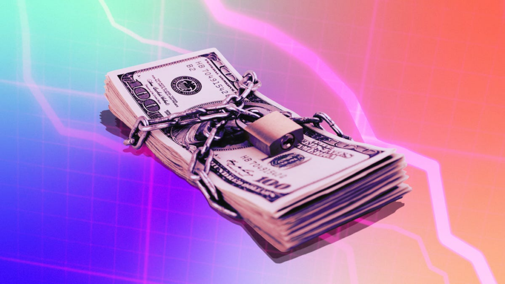 A pile of cash with a padlock wrapped around it