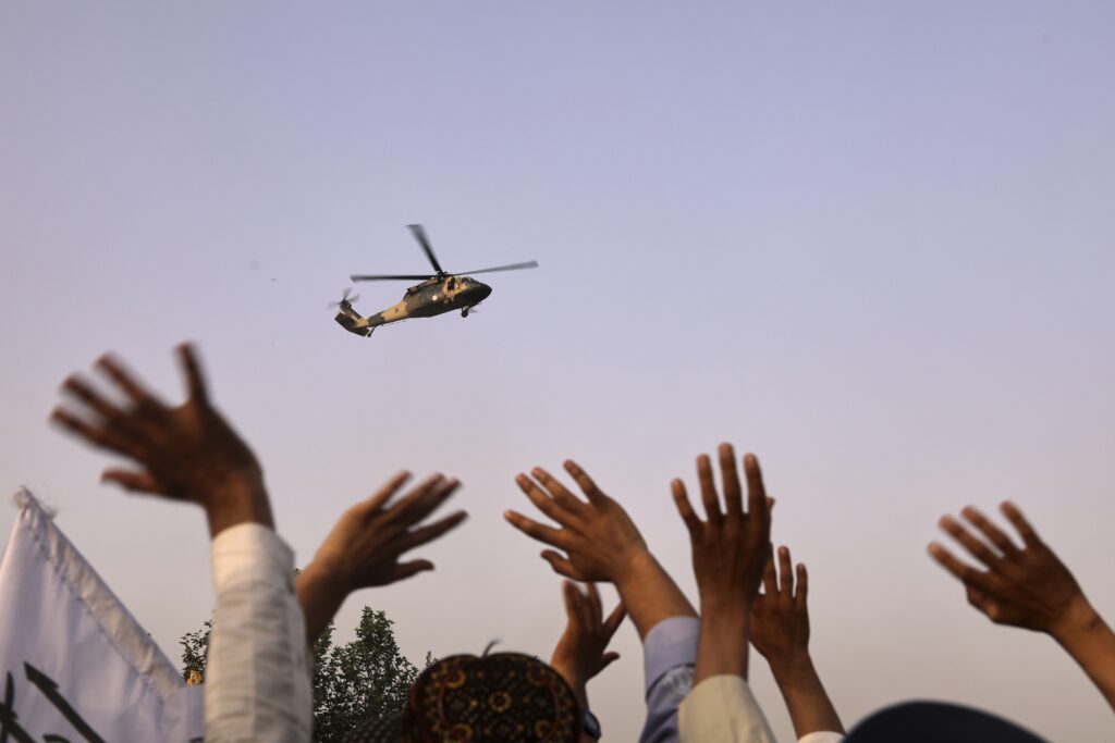 People in Afghanistan waving to military helicopter