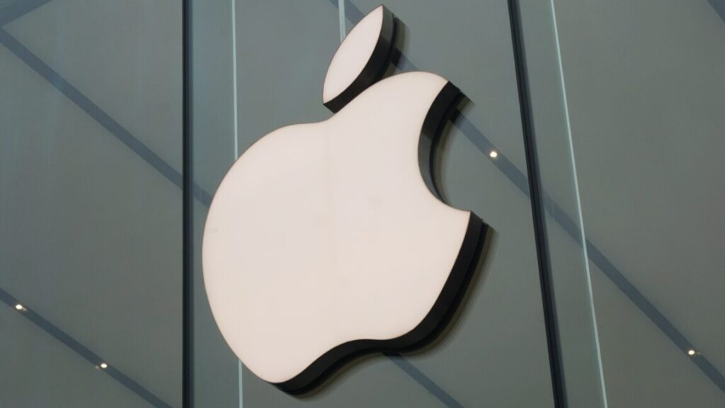 A large Apple logo on the wall at an Apple Store.