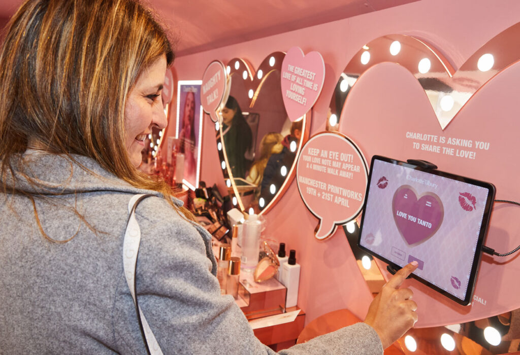 experiential design - woman pressing on iPad with a love heart on it