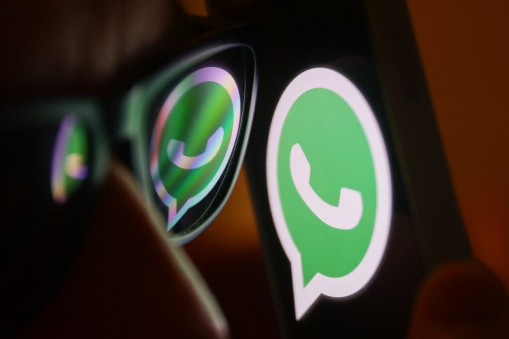 WhatsApp can now translate messages on iOS and Android WhatsApp logo reflected on sunglasses and displayed on a phone screen.