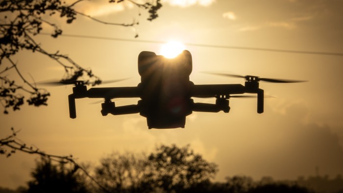 Britain’s airports will be disrupted by ‘organised’ drone attacks, warns aviation regulator A DJI Mini 5 Pro drone flies in silhouette at sunset, with trees and branches visible in the background.