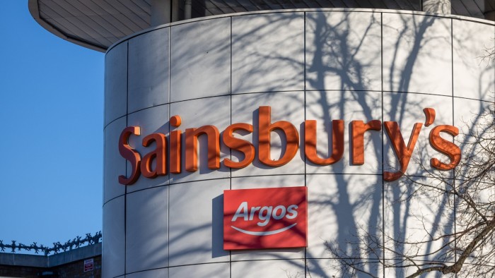 Sainsbury’s insiders take advantage of price run-up Sainsbury's and Argos logos on the exterior of a supermarket, with tree shadows cast on the building.