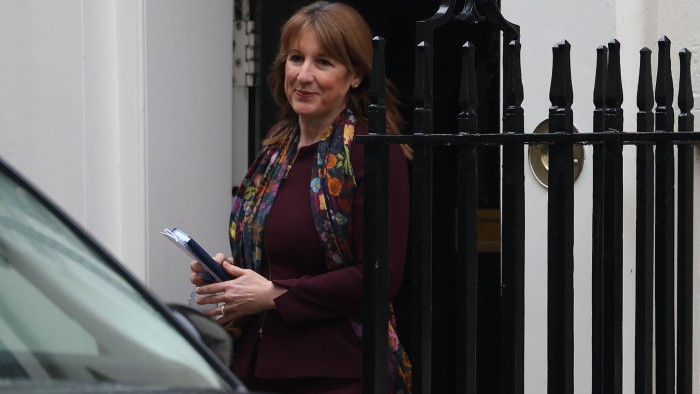 UK borrowing outstrips expectations and retail sales dive ahead of Budget Rachel Reeves leaves a building holding a notebook and pen, wearing a floral scarf and burgundy outfit.