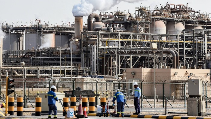 US and Saudi Arabia reach deal for rare earths facility in Gulf kingdom Three construction workers in safety gear handle materials near a trolley outside an active aluminium production facility with steam rising from pipes