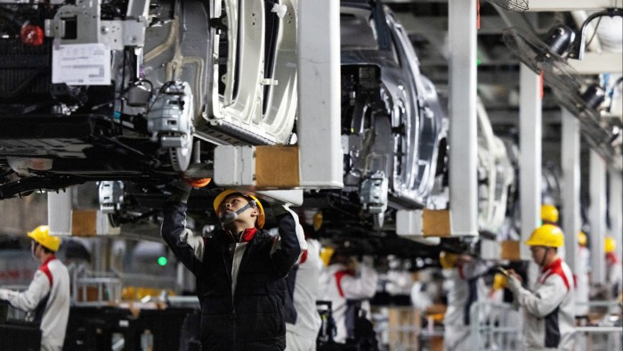 Brussels plans to scrap 2035 combustion engine ban Workers in uniforms and yellow helmets assemble vehicles on a production line at the GWM plant in Baoding, China.