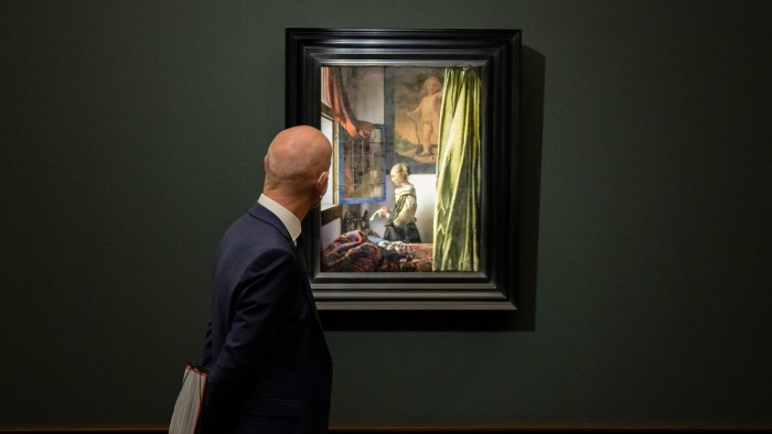 Fraudsters use AI to fake artwork authenticity and ownership A man in a suit looks at Johannes Vermeer’s painting "Girl Reading a Letter at an Open Window" displayed in a gallery.