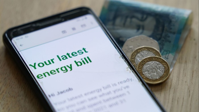 Ofgem green lights £28bn investment in UK energy infrastructure A smartphone screen showing "Your latest energy bill" next to British pound coins and a £5 note on a wooden surface.
